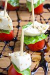 mini caprese skewers on cutting board with balsamic reduction drizzle p1