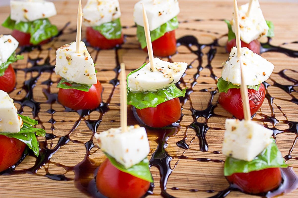 mini caprese skewers on cutting board with balsamic reduction drizzle 4