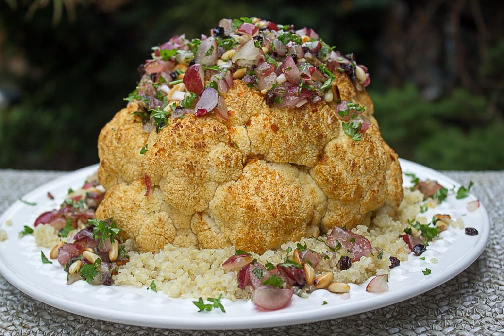 Whole Roasted Cauliflower with Fresh Grape Relish over couscous on plate