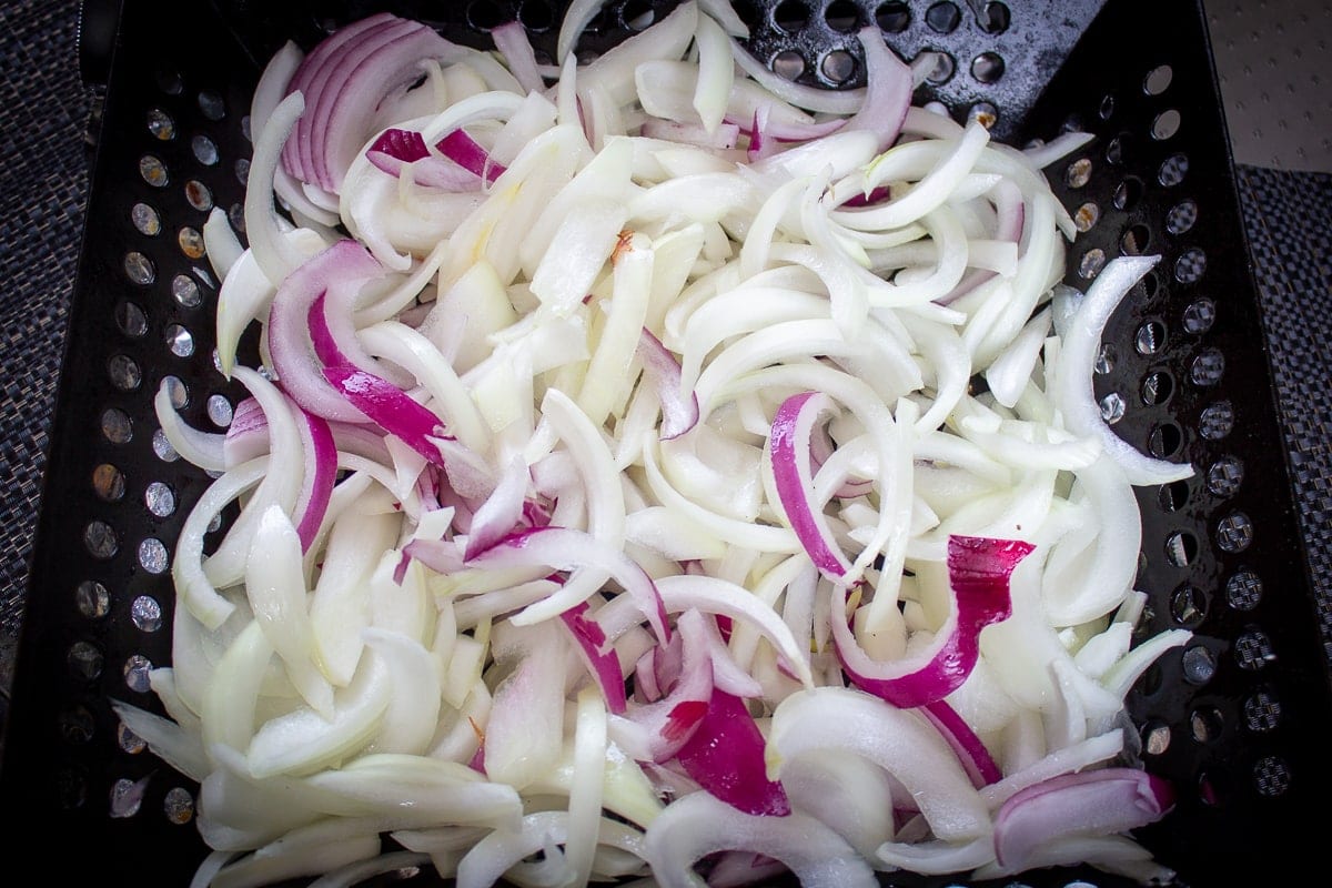 sliced onions in grill basket