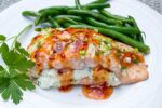 Salmon Stuffed With Lemon Ricotta drizzled with sweet chili sauce on plate with beans ff