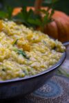 Instant Pot Pumpkin Risotto in bowl with pumpkin in background