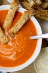 Homemade creamy tomato soup with parmesan croutons in soup p