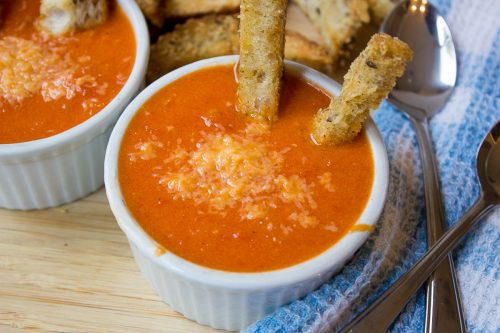 2 bowls of homemade creamy tomato soup with parmesan croutons in soup 1