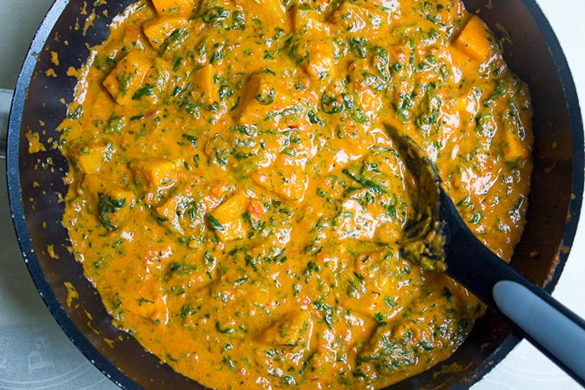 squash curry with spinach in pan