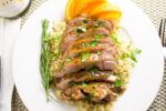 sliced boneless Turkey thighs on plate over quinoa with glaze f