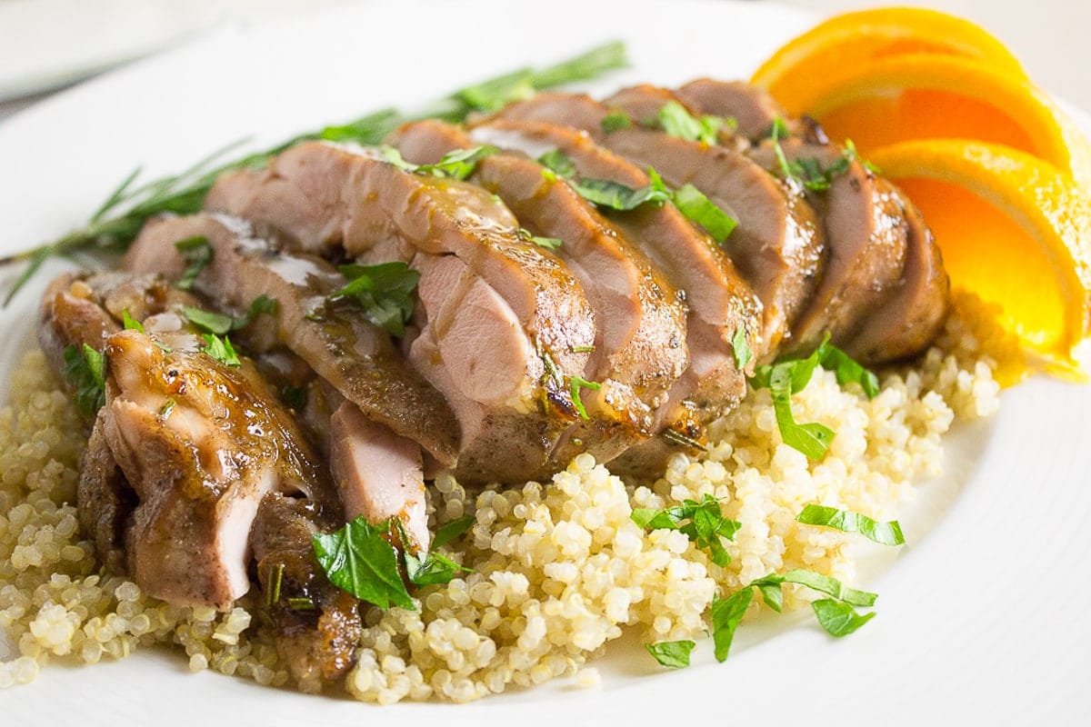 sliced sous vide turkey thighs over quinoa on plate with orange slices 2