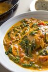 Coconut Curry Salmon with spinach and tomato served in bowl