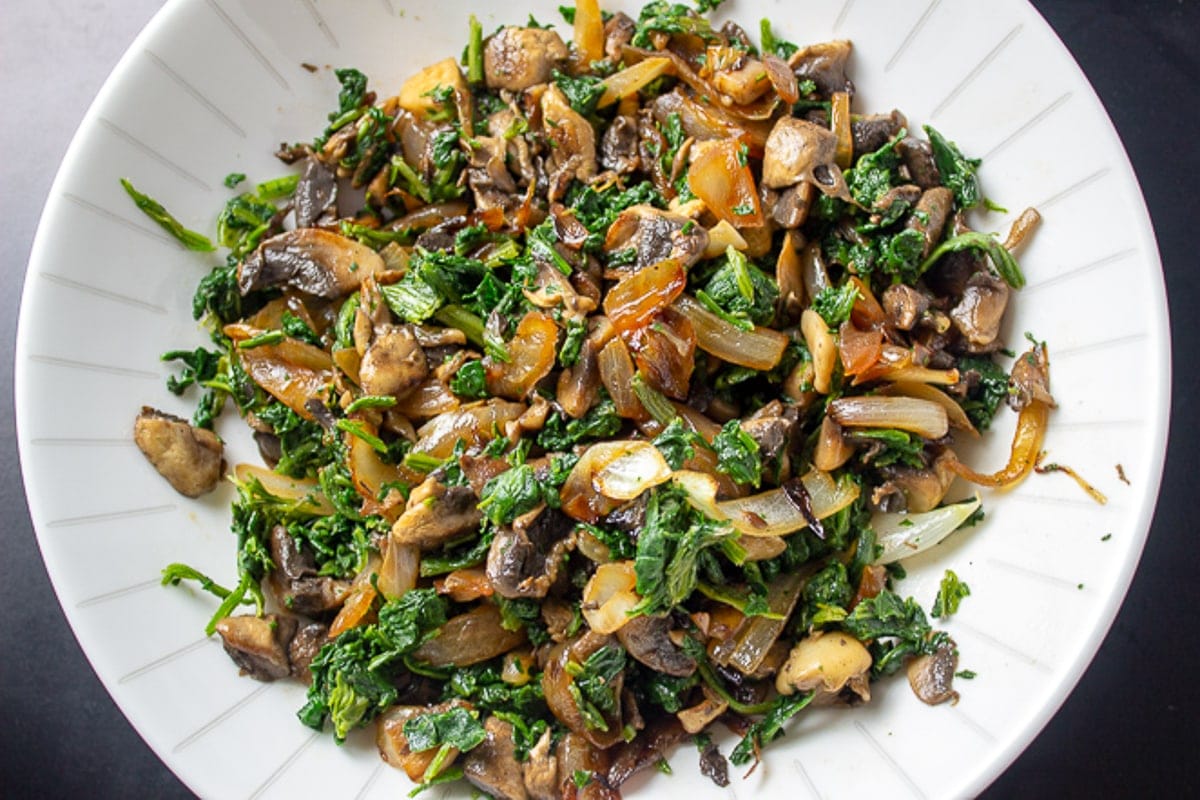 cooked spinach, mushrooms and onions in bowl