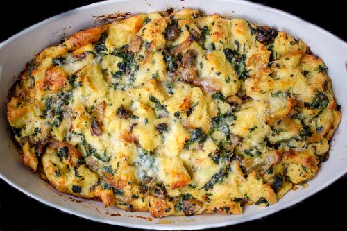 baked breakfast strata with spinach, mushrooms and cheese in casserole dish f