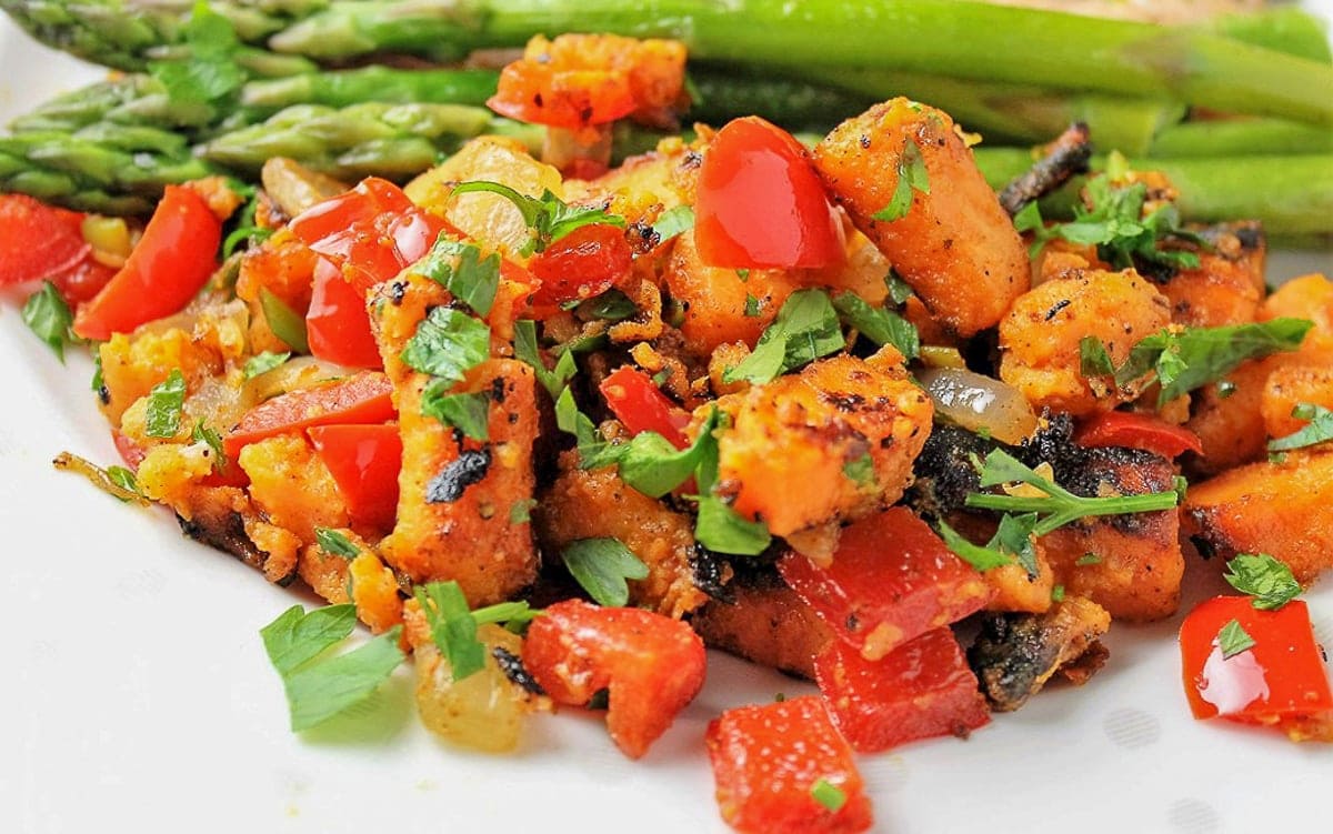 sweet potato hash on plate with asparagus