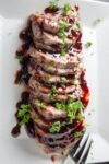 Sous Vide Pork Loin drizzled with balsamic raspberry sauce on plate