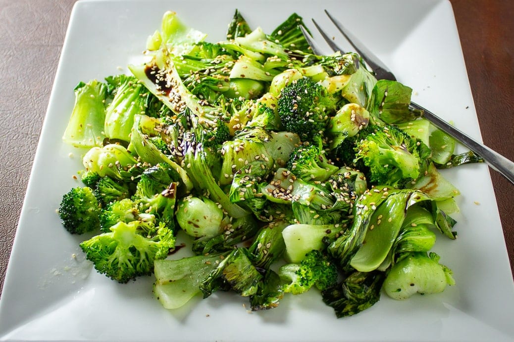 Roasted Bok Choy and Broccoli with balsamic drizzle and sesame seeds on plate