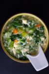 Chinese egg drop soup in bowl with spoon