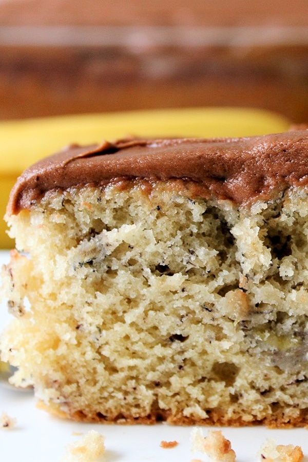 piece of banana cake with chocolate icing on plate