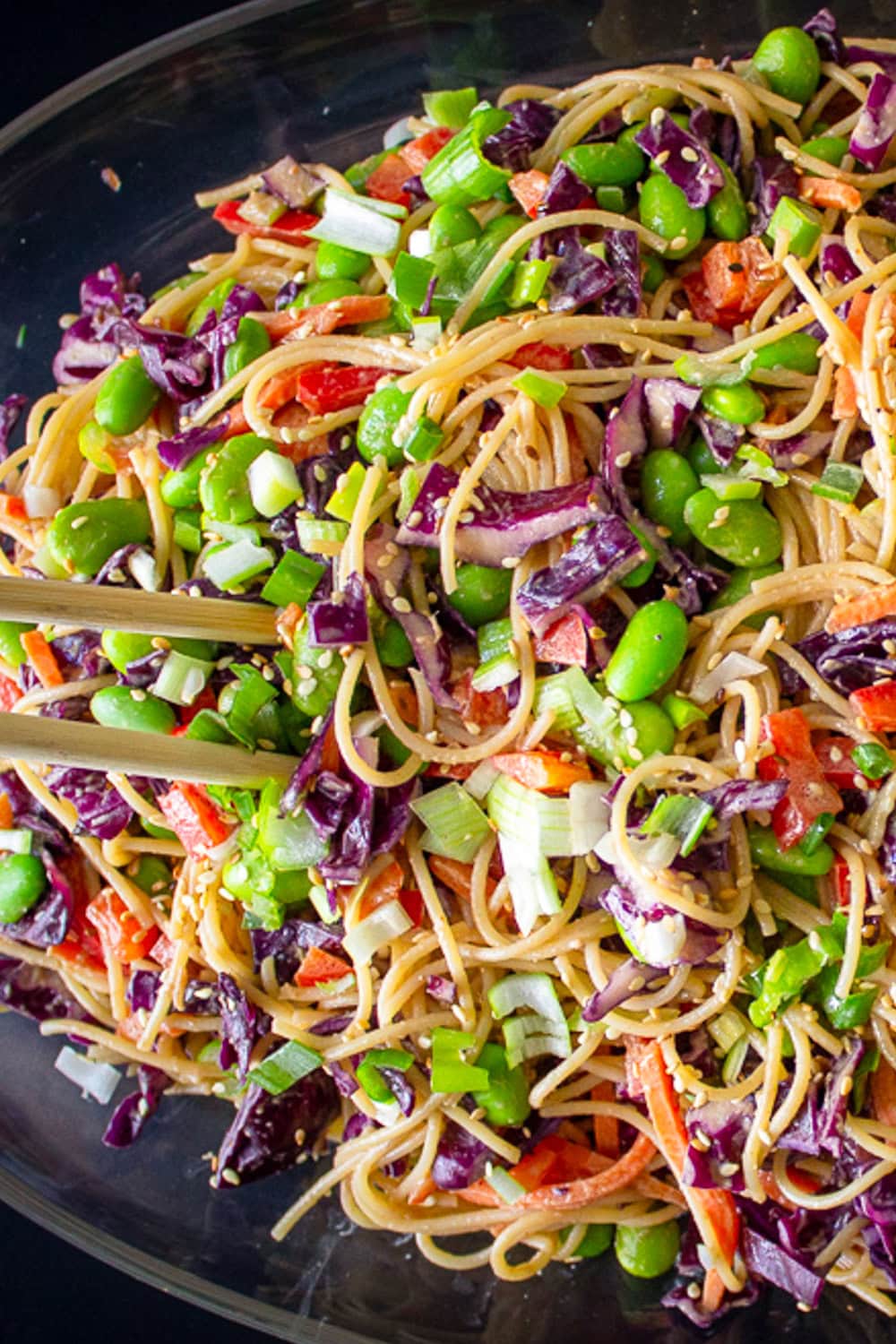 Peanut noodles and veggies on glass plate. 
