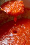 San Marzano tomato sauce dripping off ladle into pot