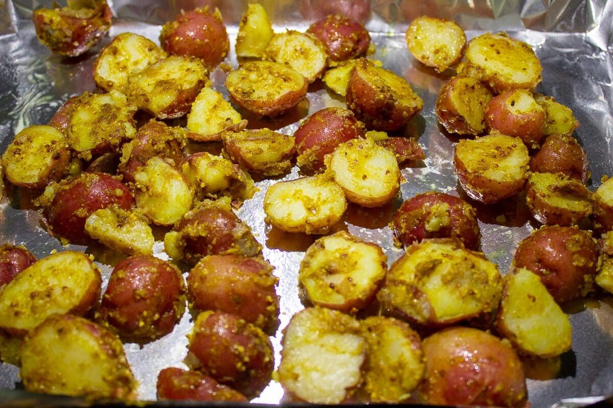 boiled potatoes mixed with spices on pan