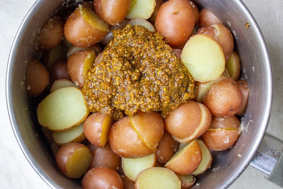 spice mix added to boiled potatoes in pot