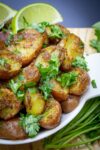 bowl of indian potatoes with lime wedges p4