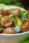 bowl of indian potatoes with lime wedges p6