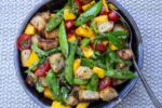 Bread salad with charred snap peas with dressing in bowl