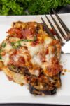 piece of Eggplant Parmesan on plate with fork p6