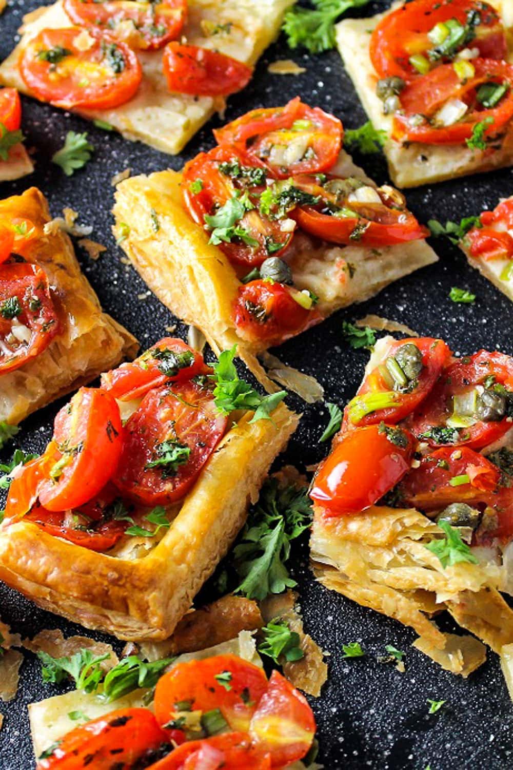 cut up tomato tart for appetizers on cutting board