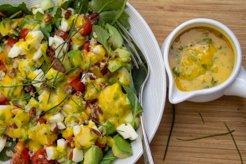 Mango Salad Dressing on salad with dressing in cup on the side