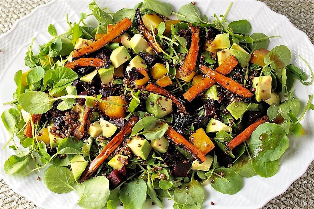 Red quinoa salad with roasted carrots and beets in shallow serving dish