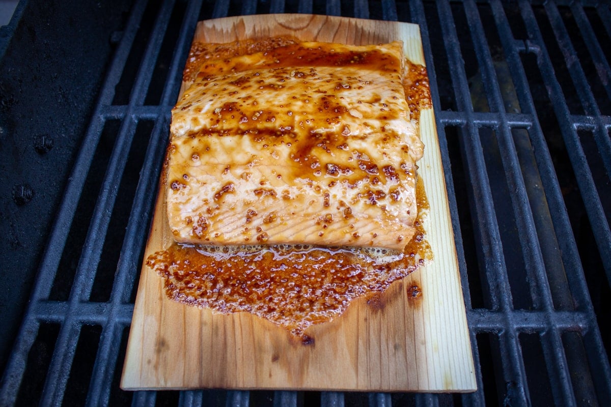 partially grilled salmon on plank on grill