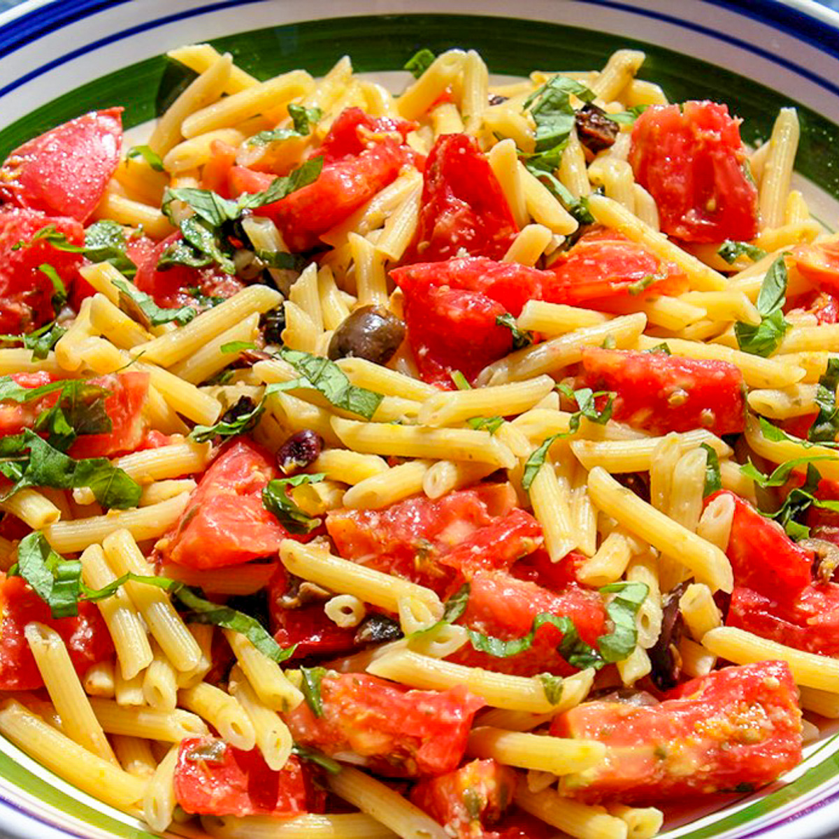 bowl of fresh tomato and olive pasta