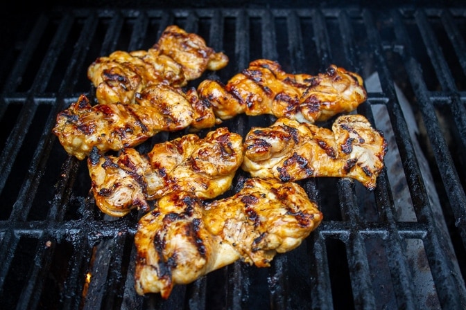 boneless marinated thighs cooking on grill