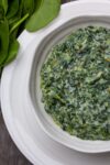 easy creamed spinach in bowl resting on plate