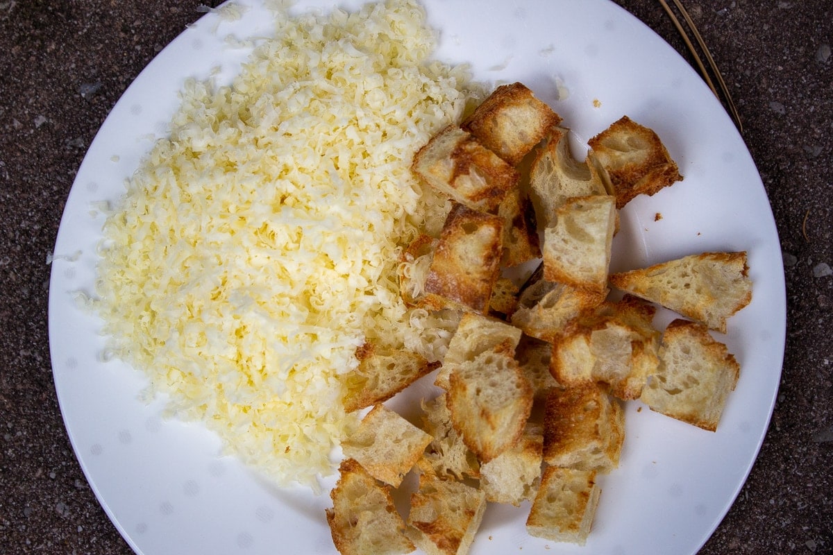 toasted bread cubes and grated cheese on plate