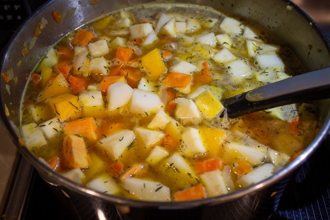diced root vegetables with broth and seasonings in pot