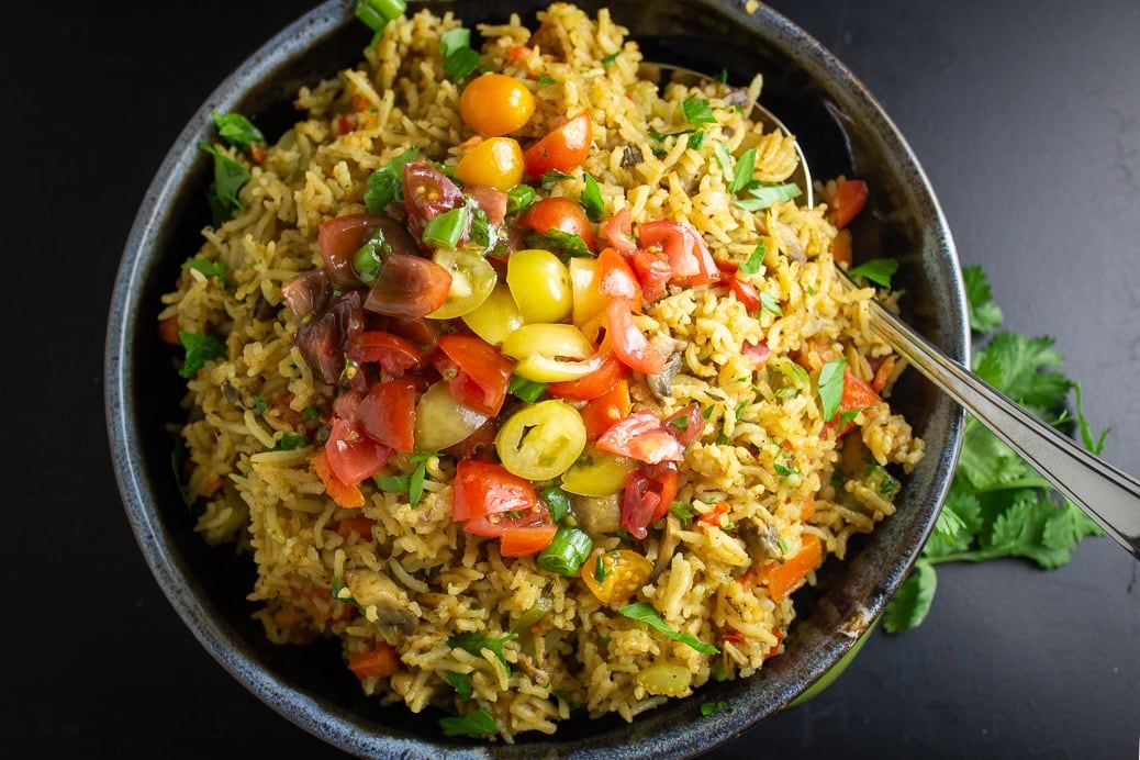 Vegetable Rice in bowl topped with fresh tomato salad