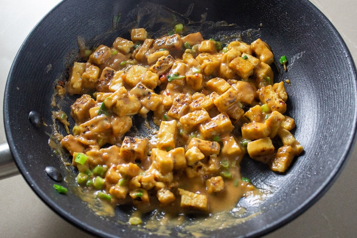 cubed tofu with peanut sauce in pan
