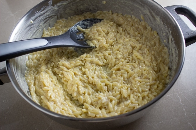 orzo cooked in pan with broth and milk