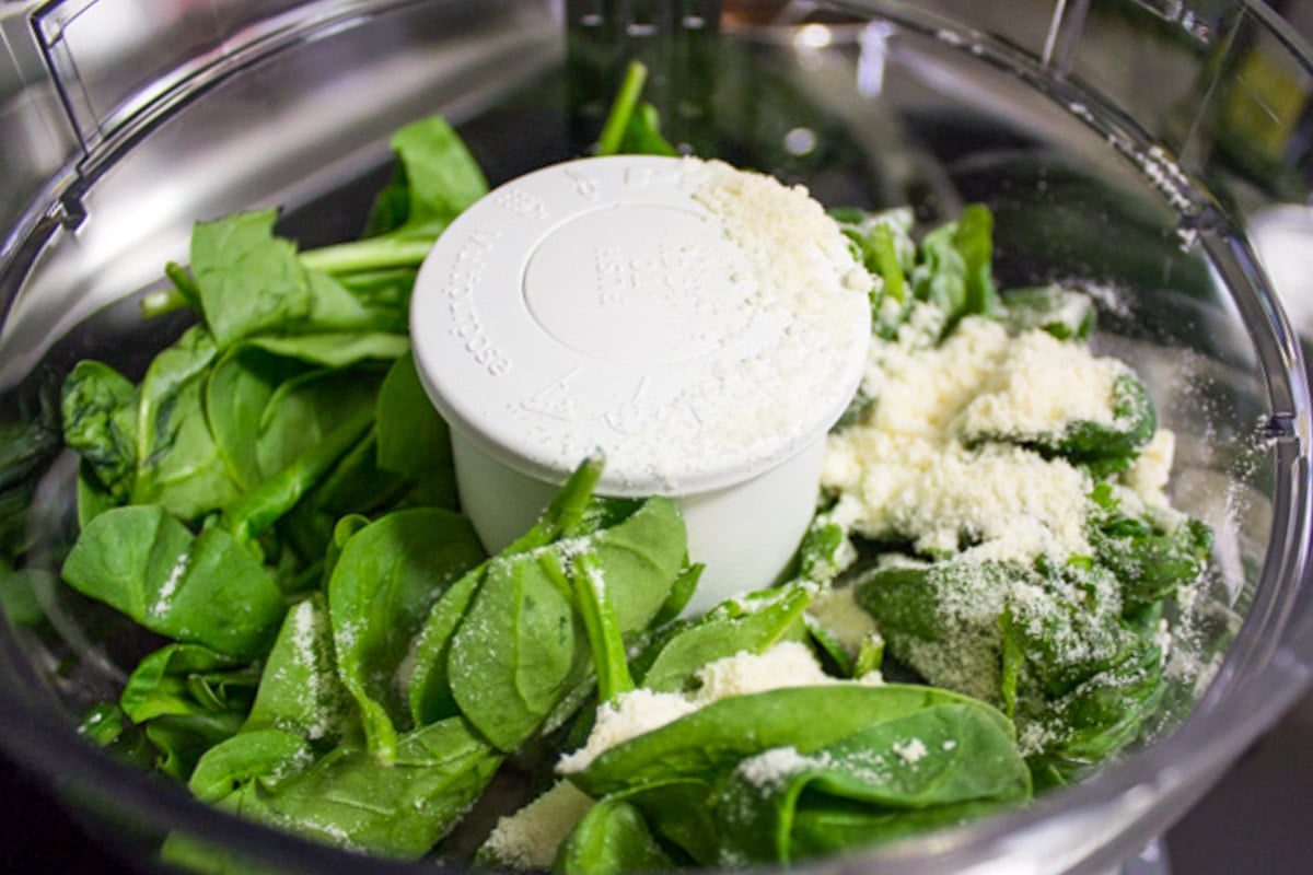 Pesto ingredients in food processor bowl.
