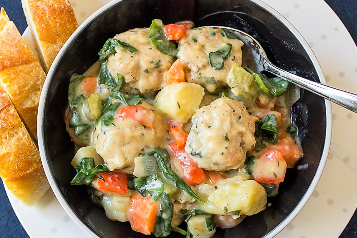 bowl of chicken meatballs in sauce with veggies