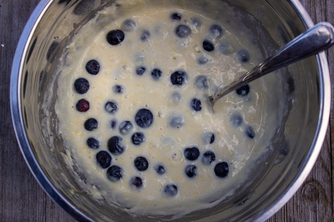 blueberries incorporated into pancake batter in a bowl