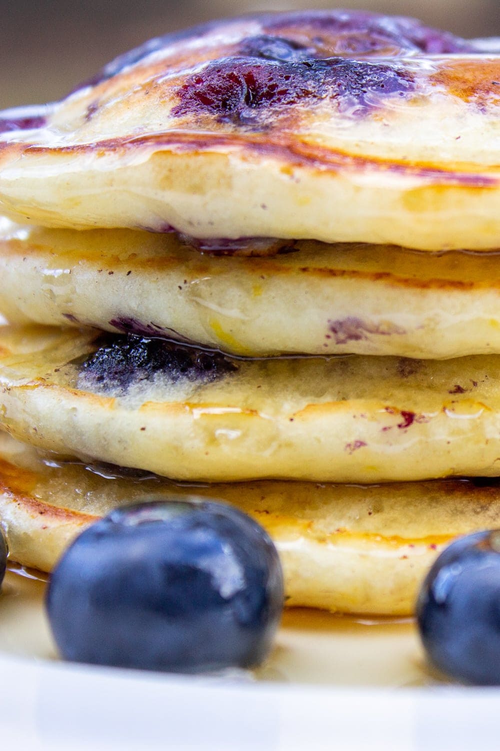stack of lemon blueberry pancakes in plate with syrup on top and fresh blueberries p1