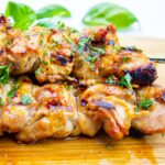chicken thigh skewers stacked on cutting board