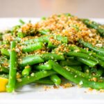 green beans topped with panko breadcrumb mixture on plate