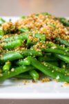 green beans topped with panko breadcrumb mixture on plate p