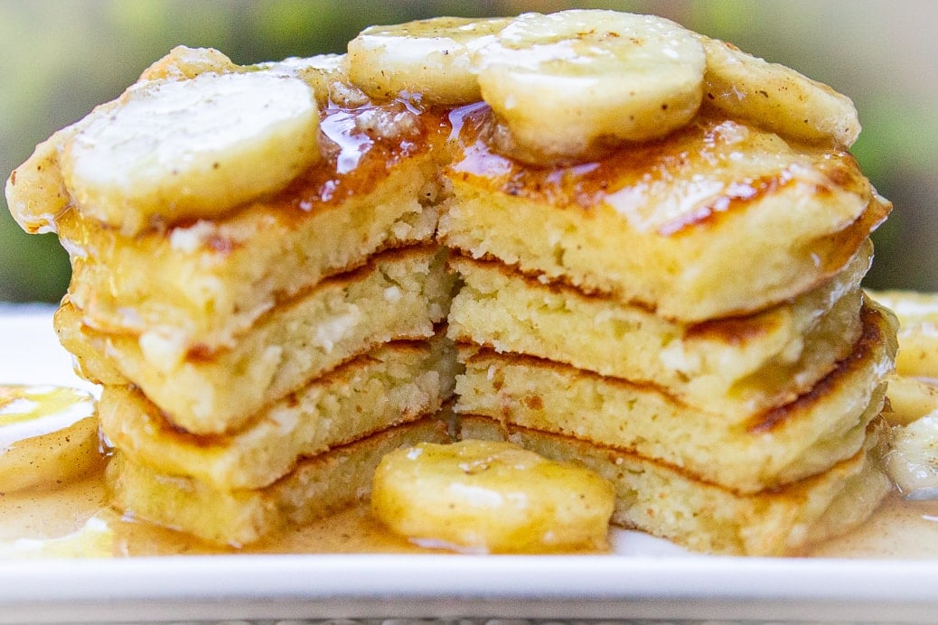 stack of ricotta pancakes cut open cut open with caramelized bananas on plate 2
