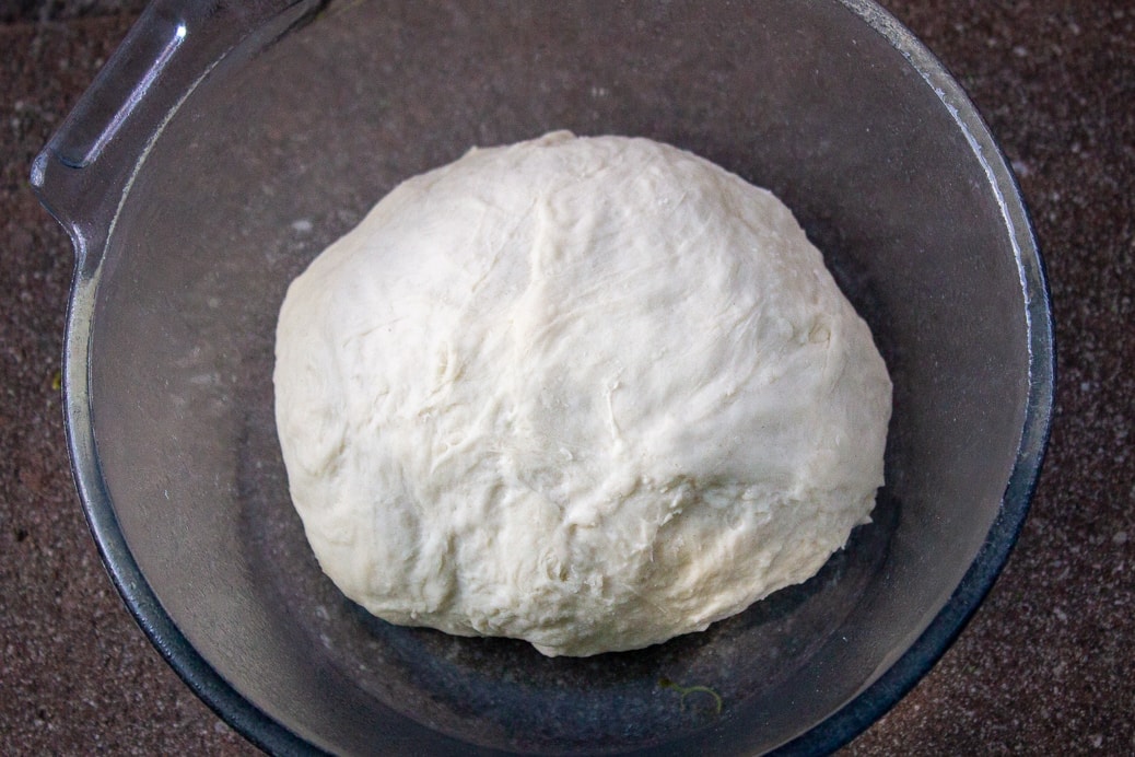 rolled piece of dough in bowl ready to rise