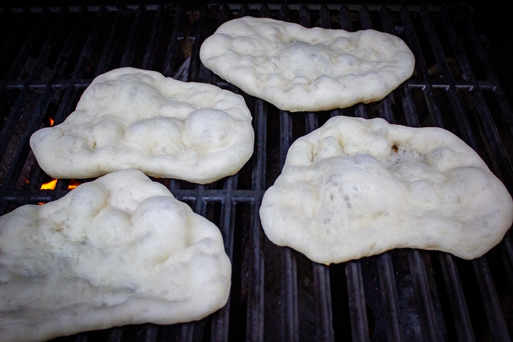 4 naan on grill raw side up and bubbling