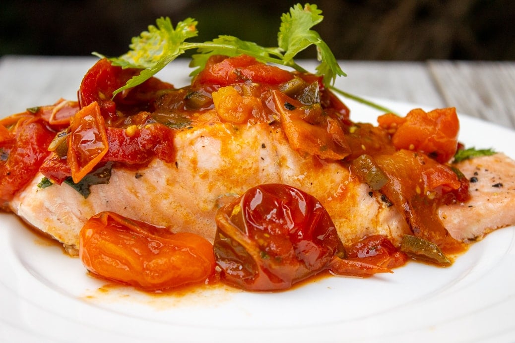 cherry tomato sauce served over salmon on plate